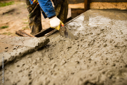 worker pours concrete mortar on a construction site