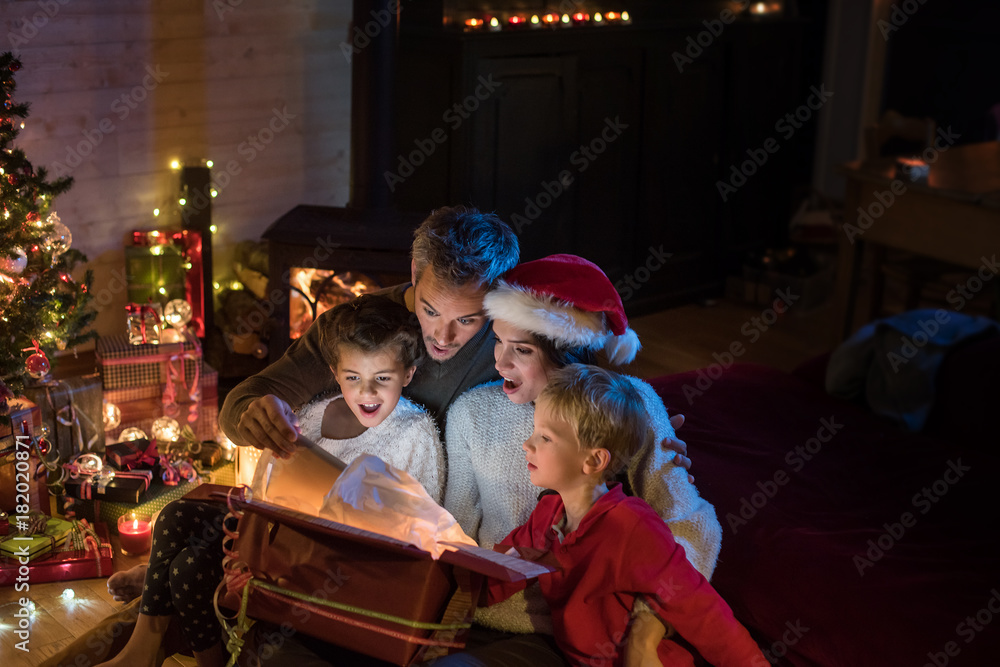Christmas night, a cheerful family find a digital tablet in a gift box