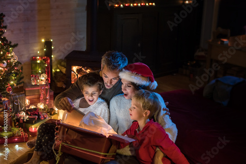 Christmas night, a cheerful family find a digital tablet in a gift box