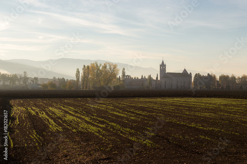 Country near Assisi (Umbria) at dawn, with cultivated field and Rivotorto church at the distance