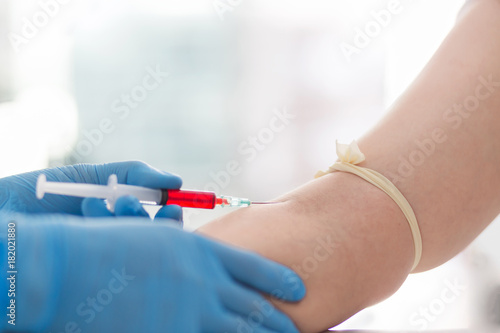 Close up Hand of nurse  doctor or technician in blue gloves taking blood sample from a patient in the hospital.