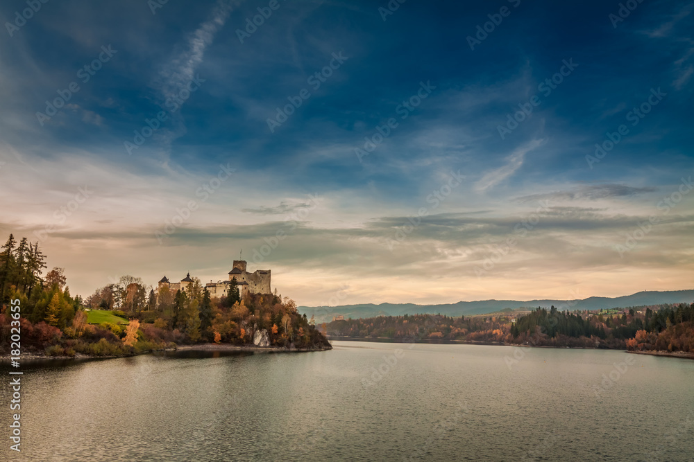 Wonderful castle by the lake in autumn at dusk
