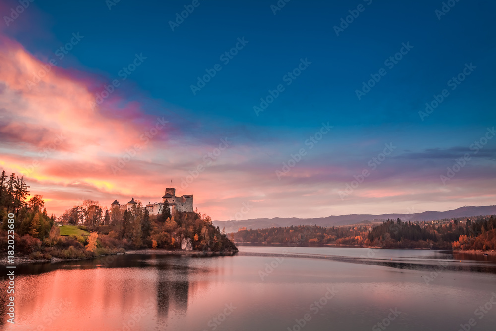 Wonderful castle by the lake in autumn at sunset