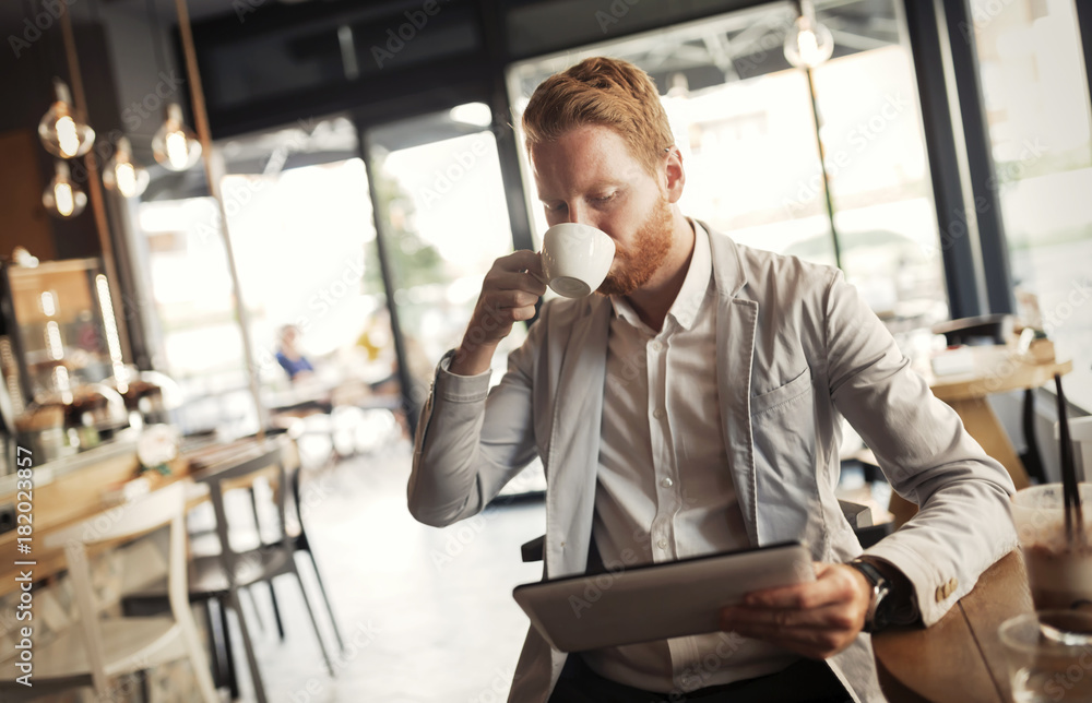 Busy businessman enjoying coffee while online Busy businessman enjoying coffee while online