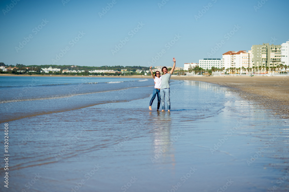 Young couple stands having embraced in water on the sea coast.