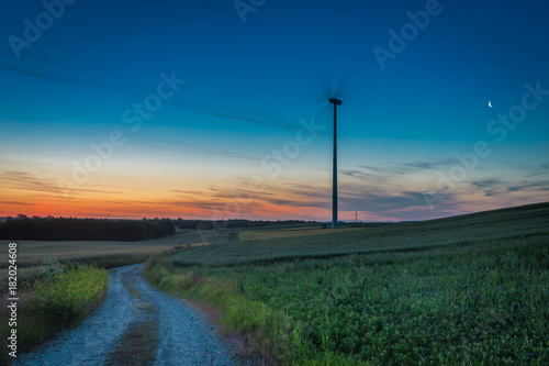 Stunning dusk over field with wind turbines