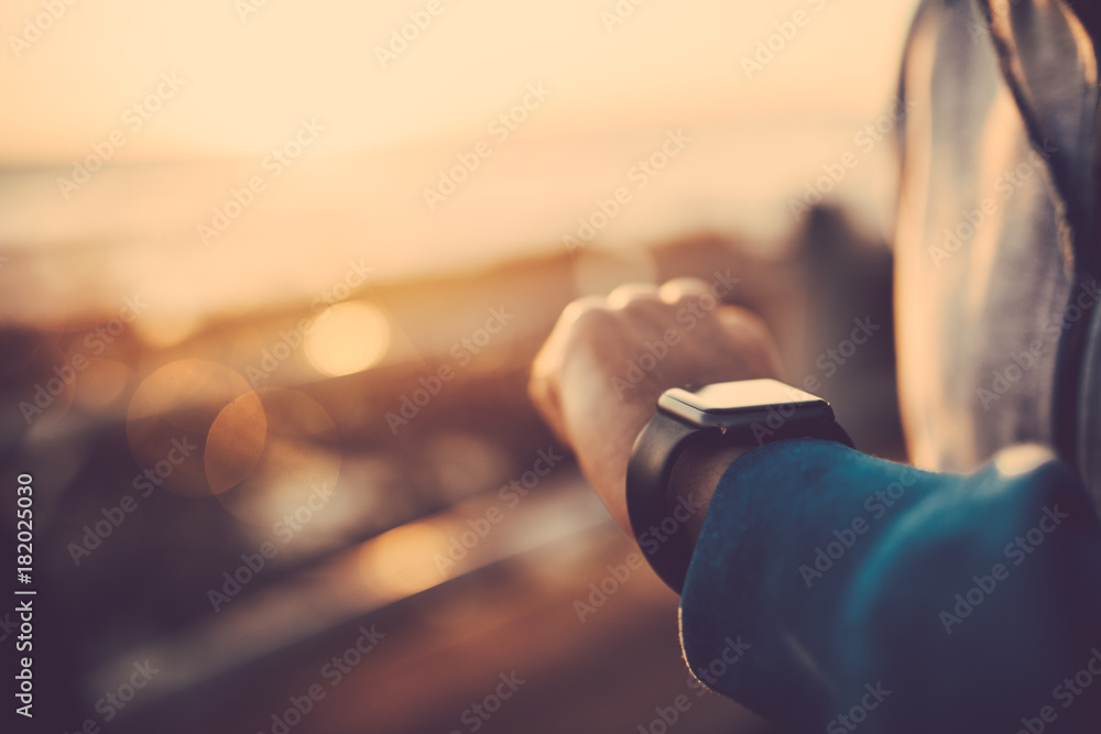  Close up of man using his smart watch outdoors
