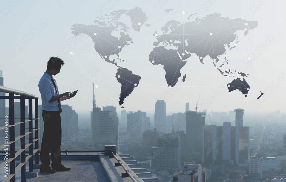 Businessman use smartphone on rooftop of building with technology effect, globalization conceptual Businessman use smartphone on rooftop of building with technology effect, globalization conceptual