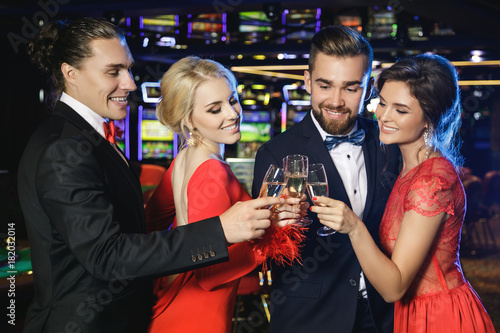 Group of happy people drinking sparkling wine in the casino photo