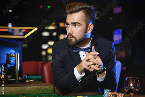 Handsome man playing roulette in the casino
