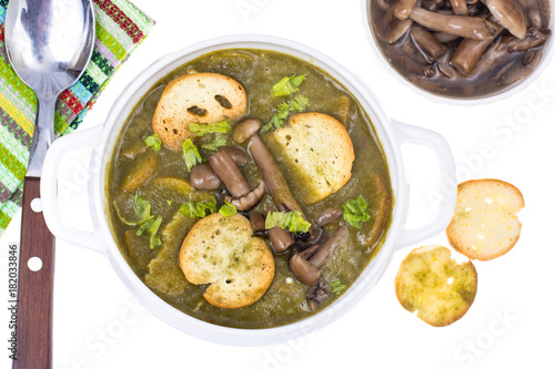 Green cream soup with croutons and mushrooms