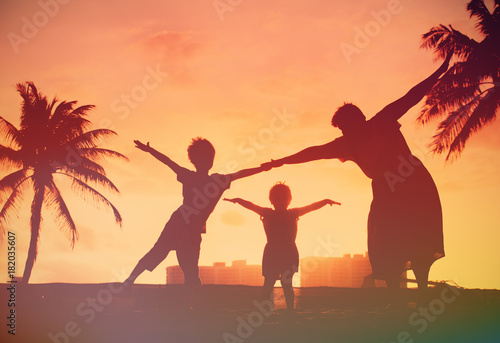 silhouette of family with kids play at sunset beach © nadezhda1906