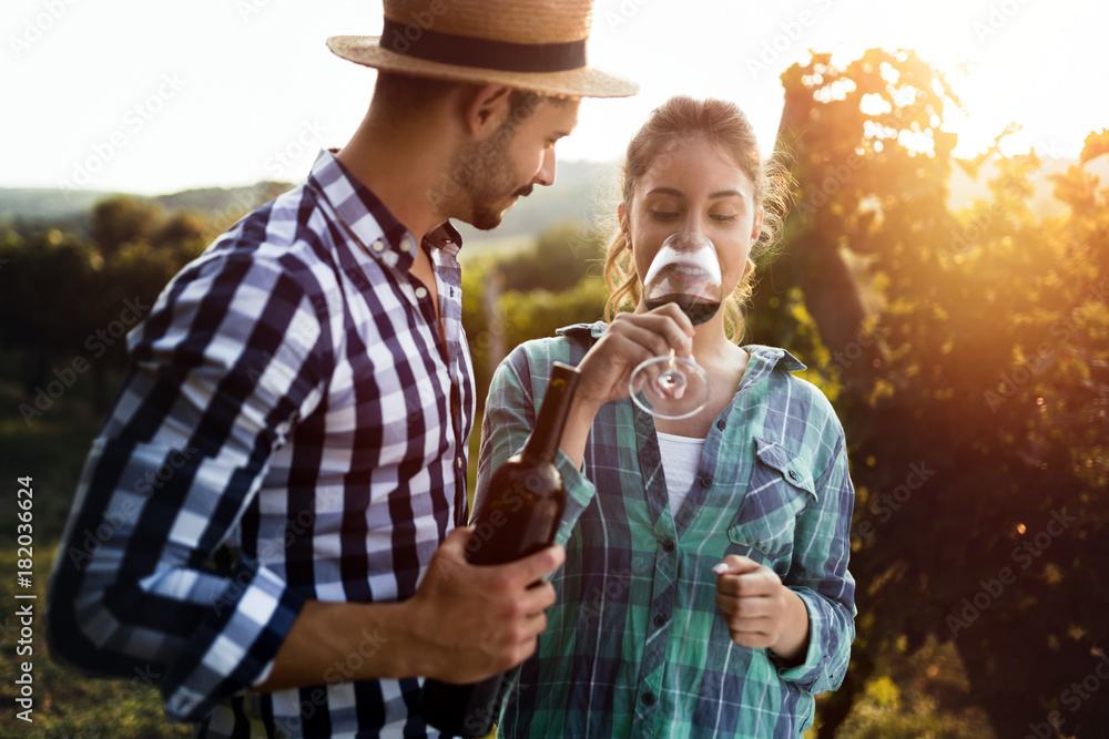 Fototapeta premium Woman tasting wine in wine grower vineyard