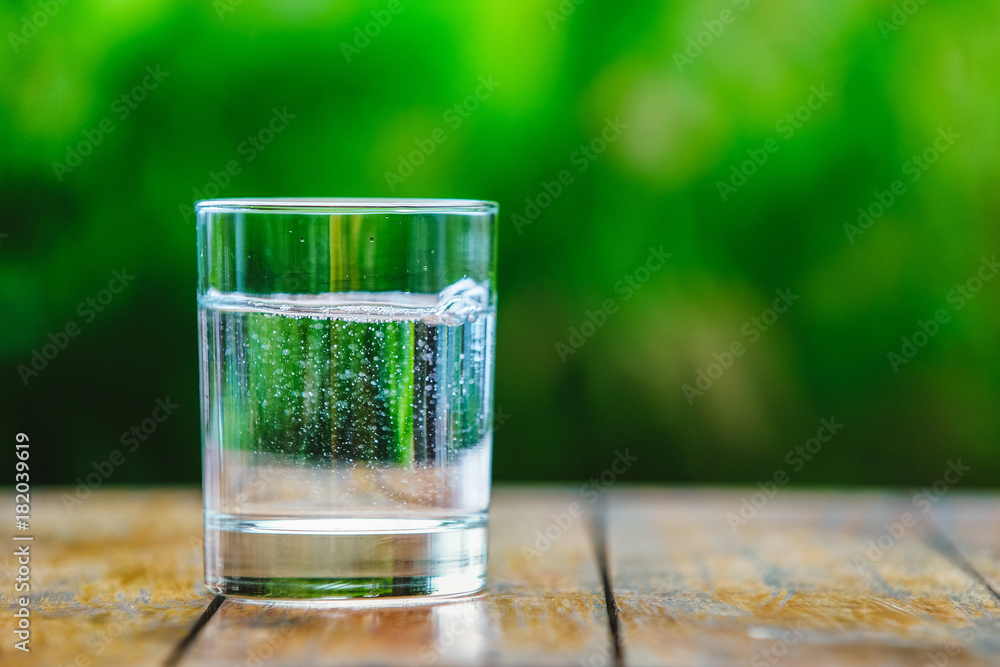 A glass of water on green background A glass of water on green background