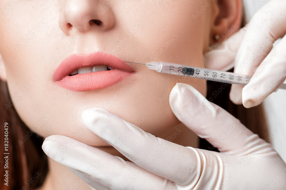 woman getting injection on lips. woman getting injection on lips.