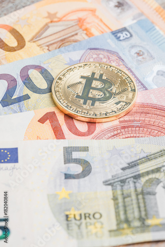 Bitcoin on Euro banknotes at table