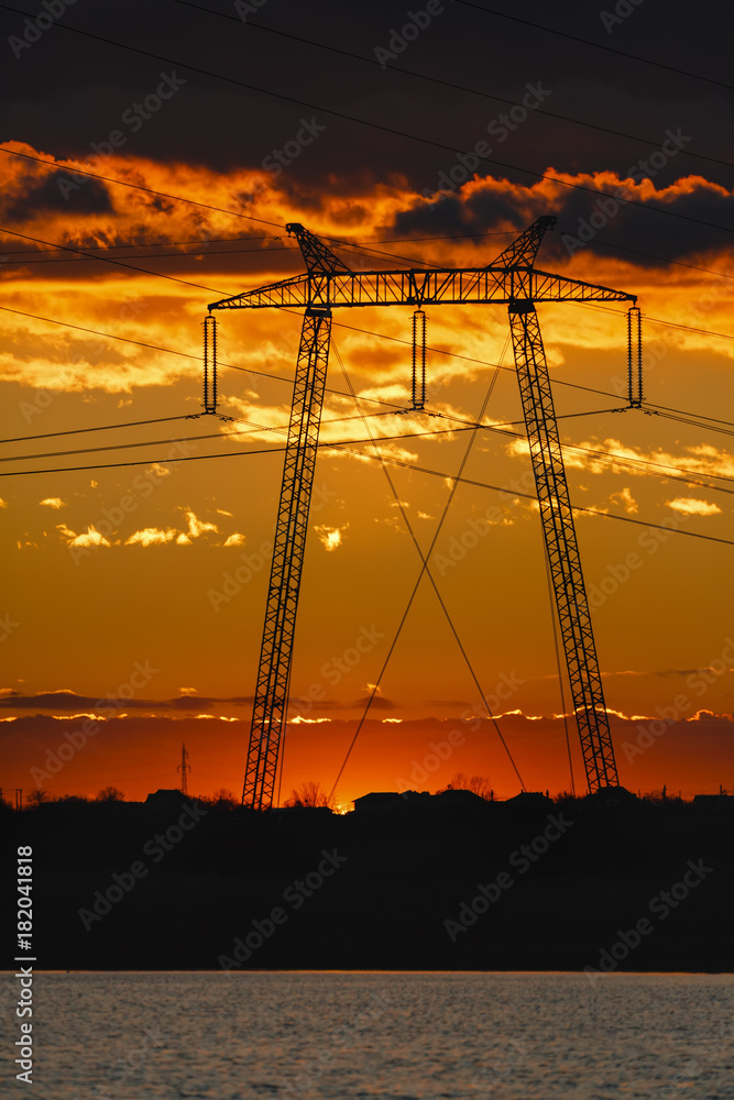 landscape with high-voltage poles at sunset