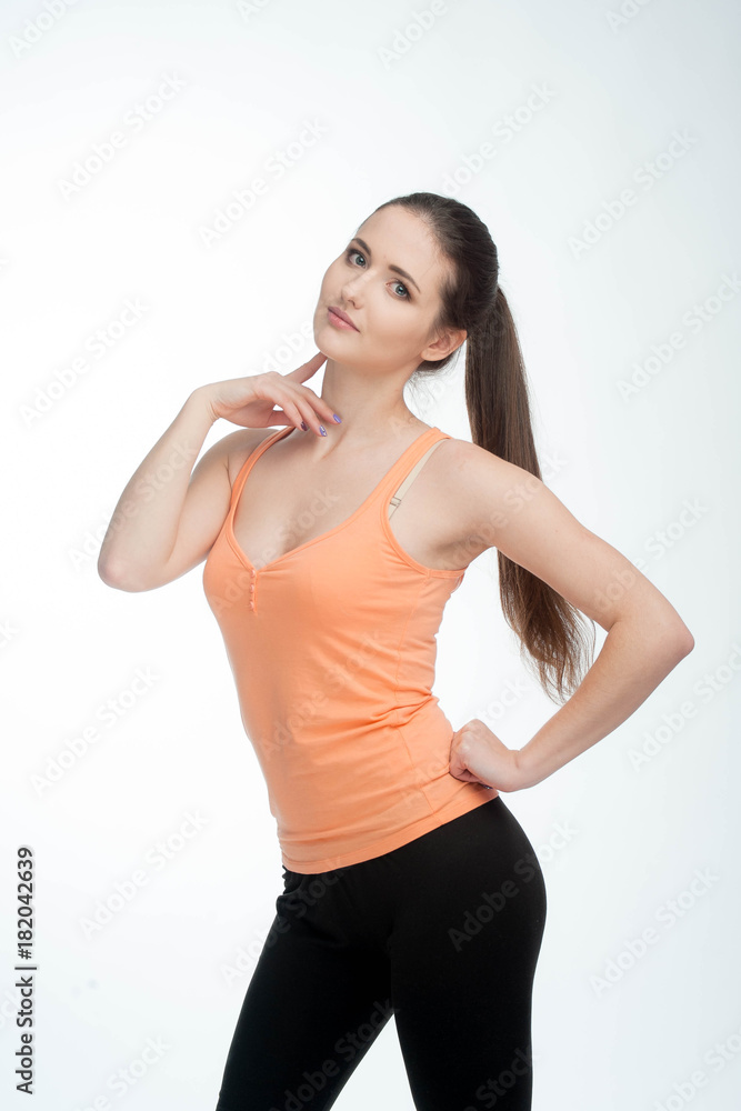 Sports girl posing isolated on a white background. Fitness model woman in studio with copy space.