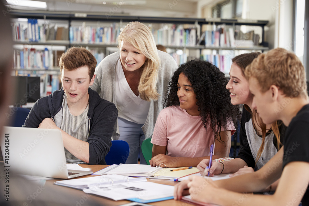 Female Teacher Working With College Students In Library Female Teacher Working With College Students In Library