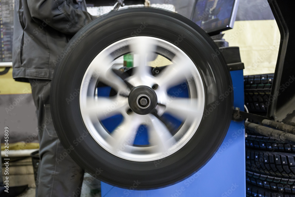 Process of balancing and fitting car tire wheel in motion, auto repair service, garage Process of balancing and fitting car tire wheel in motion, auto repair service, garage