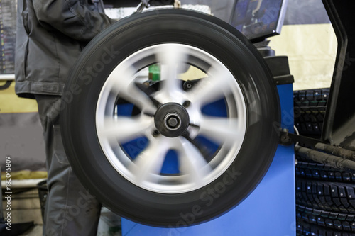 Process of balancing and fitting car tire wheel in motion, auto repair service, garage