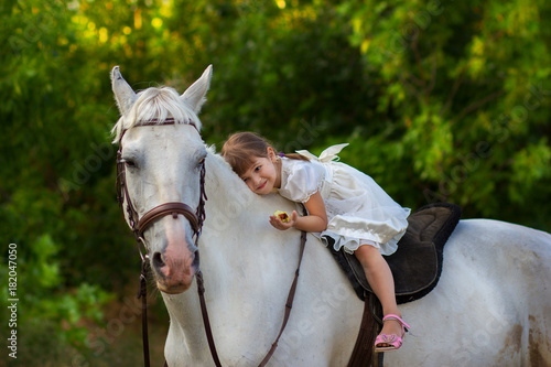 the little girl lies on a horse
