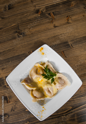 Meat dumplings - russian pelmeni, ravioli with meat on a wooden background. with copy space. top view