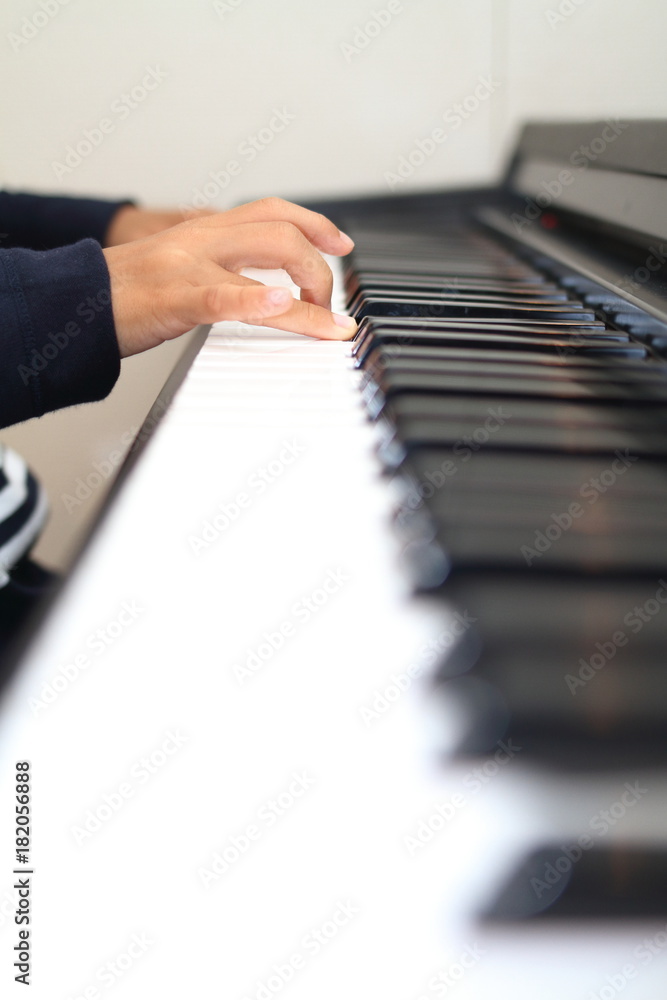 Obraz premium ピアノを弾く小学生(2年生)の手