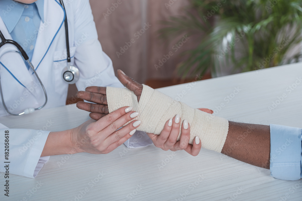 doctor bandaging patient hand