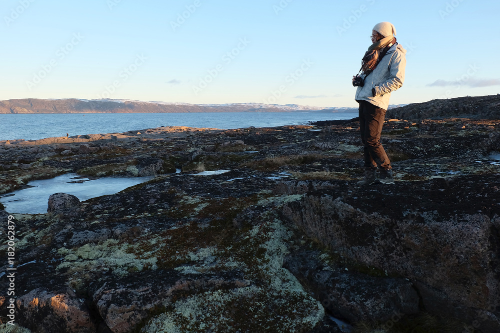 Woman traveler standing with beautiful landscape of tundra meadow