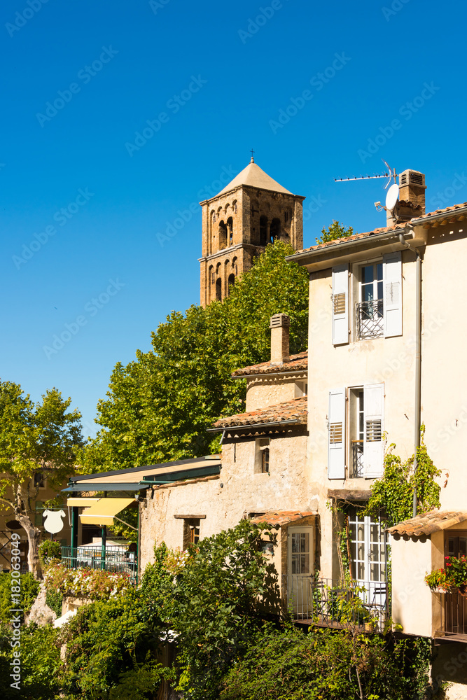 Das Bergdorf Moustiers-Sainte-Marie in Südfrankreich mit seinen alten Häusern und der kleinen Pfarrkirche im Hintergrund umgeben von Felsen in der Provence
