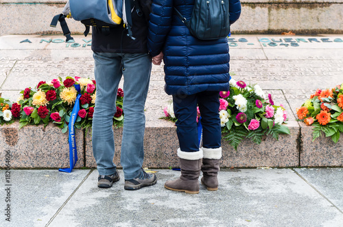 Low Section Shot of Couple Wearing Jeans in Front of the Gëlle Fra Memorial in Luxembourg City, Luxembourg photo