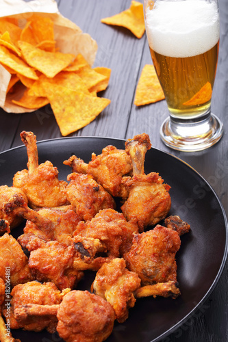 close-up of chicken wings, nachos, beer
