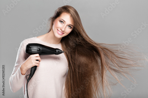 woman drying her hair with dryer 