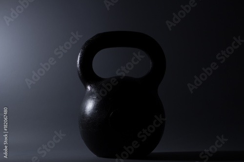 Fototapeta Naklejka Na Ścianę i Meble -  iron kettlebell weight on a dark background. Sports Equipment.