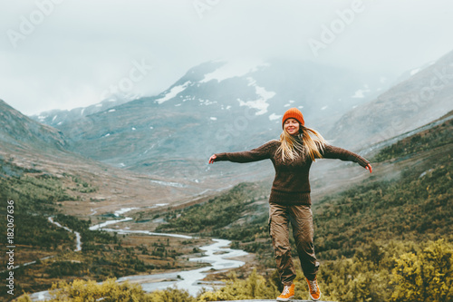 Woman bliss emotional raised hands foggy mountains on background Travel Lifestyle wellness concept adventure vacations outdoor harmony with nature Jotunheimen park in Norway