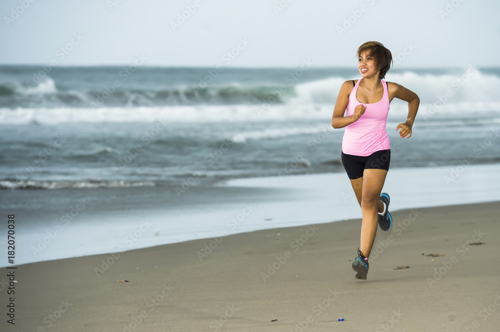 young attractive and fit Asian sport runner woman running on beach sea side smiling happy in fitness young attractive and fit Asian sport runner woman running on beach sea side smiling happy in fitness