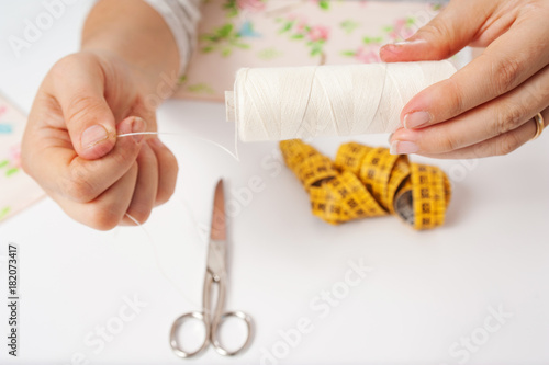 hands of young woman sewing