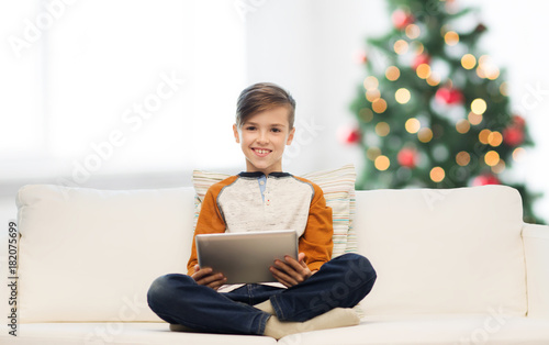 smiling boy with tablet pc at home at christmas photo