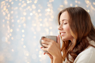 happy woman with cup of tea or coffee at home