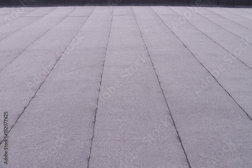 Flat surfaced roof coating. Heating and melting bitumen roofing felt background pattern.