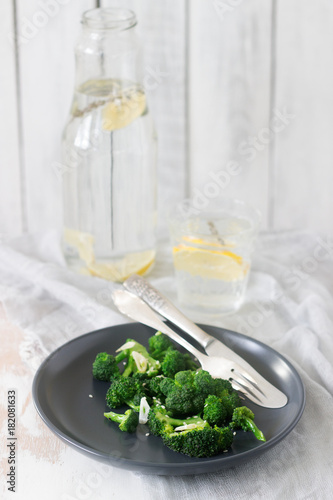 Broccoli cooked with garlic, ginger and sesame served with lemonade. Rustic style.