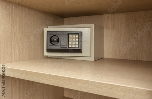 Safe box for storing valuables in a wooden cupboard.