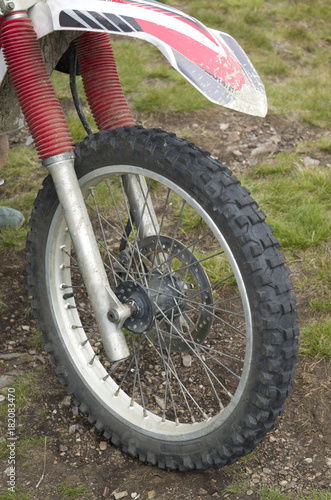 Front tire and fender on motorcycle with red damper