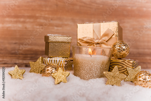 Goldene brennende Kerze mit Weihnachtsdeko