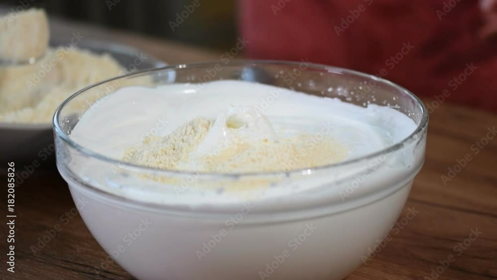 Mix the meringue with the almond flour. Woman's hands mixing sweet dough Mix the meringue with the almond flour. Woman's hands mixing sweet dough