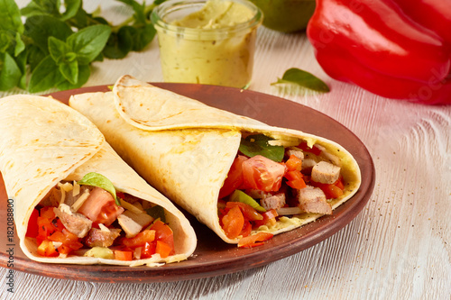 Two tortilla wraps with roasted turkey and vegetables