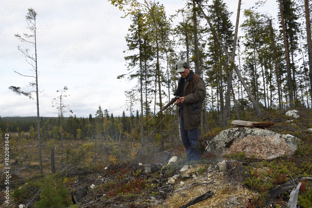 Obraz premium Moose hunter with a little fire using his smartphone