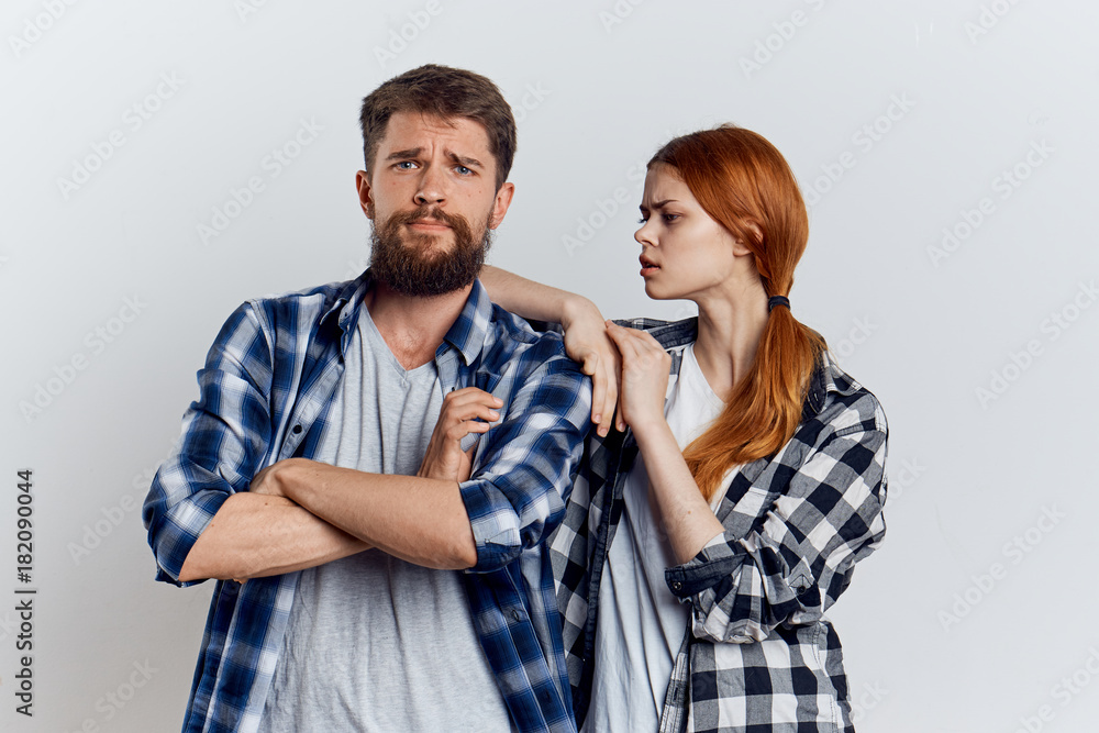 Young beautiful woman together with a bearded man on a light background, attitude Young beautiful woman together with a bearded man on a light background, attitude