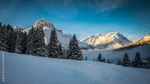 Sunset in Lech, Austria with fog in the village